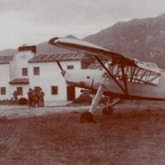la avioneta remolcador "Cigüeña" en espera frente a las casas de la Escuela de vuelo de Llanes